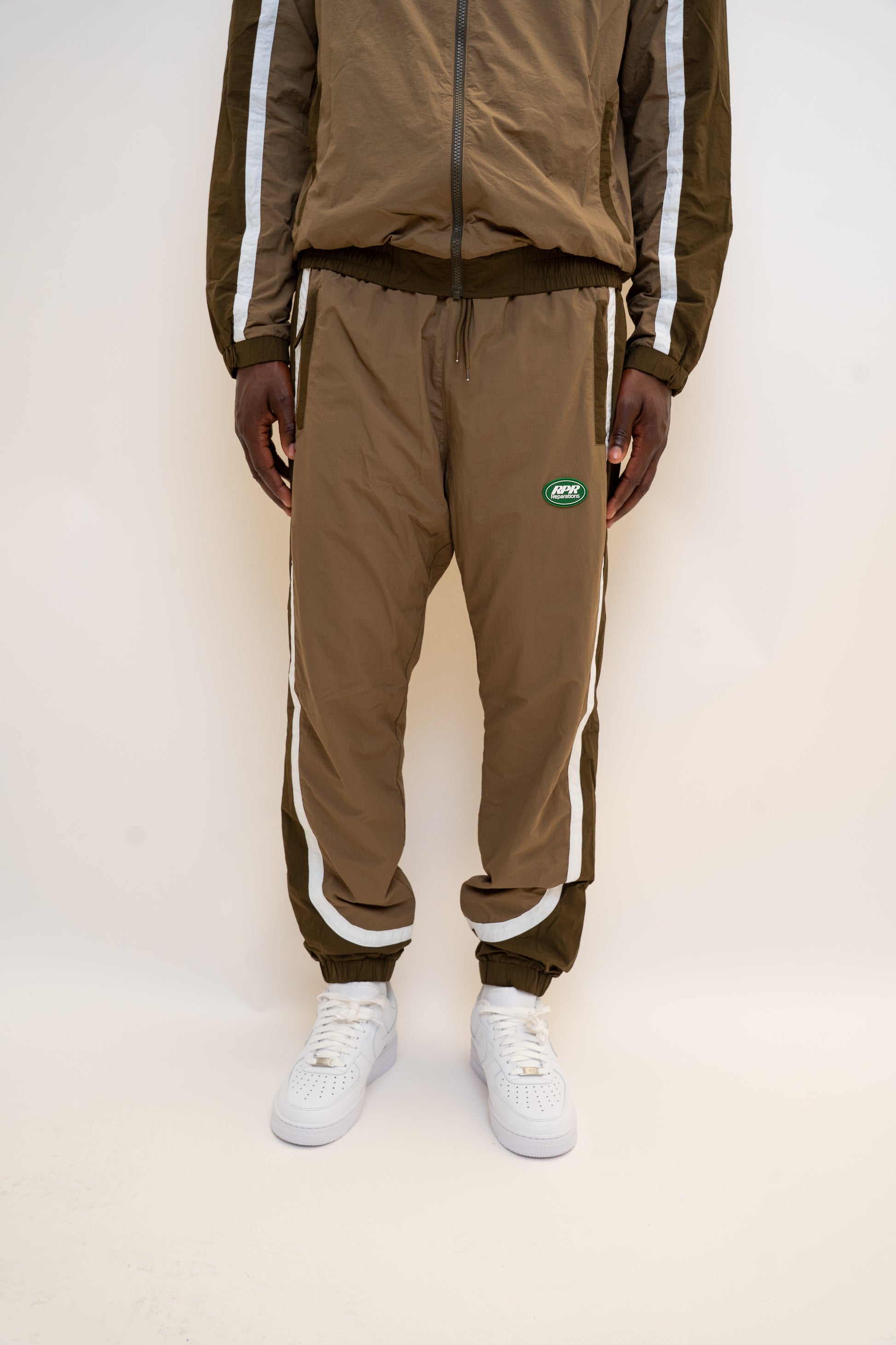 khaki tracksuit

brown nylon tracksuit

RPR DopeBoy set

military green tracksuit

unisex two-piece activewear

full zip tracksuit with logo

lightweight streetwear set

mesh-lined tracksuit

nylon jacket and pants set

urban utility style tracksuit