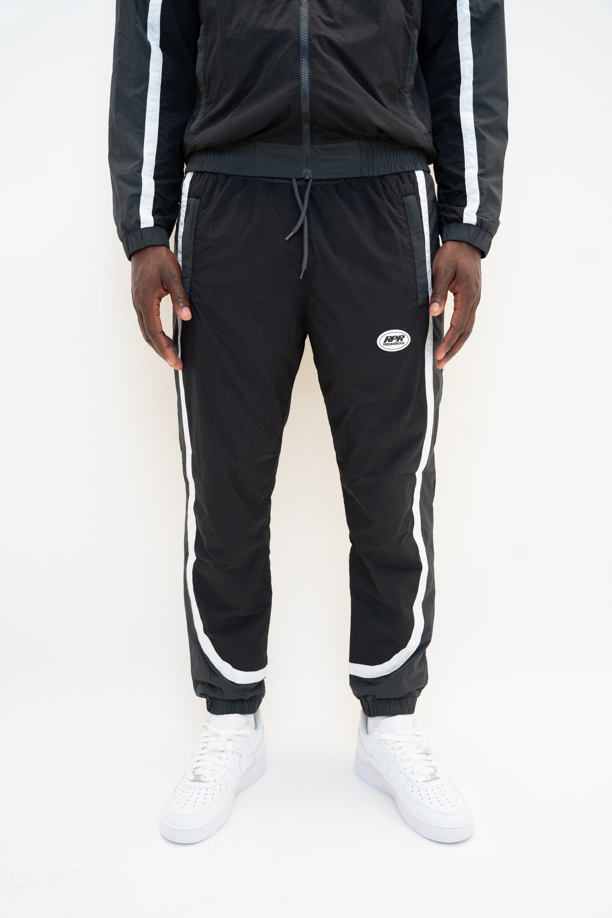 black nylon tracksuit

charcoal grey tracksuit set

RPR DopeBoy tracksuit

full zip athletic set

unisex streetwear tracksuit

mesh lined jacket and pants

relaxed fit activewear

tapered jogger set

men’s black tracksuit

lightweight nylon two-piece